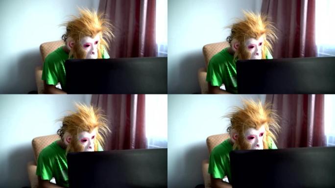 猴子面具里的滑稽男人在电脑后面工作。幽默超现实。拖延概念