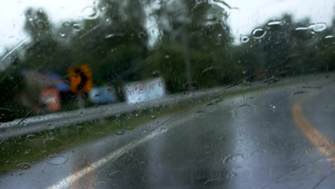 下雨，在下雨的时候在路上行驶，雨滴滴在玻璃窗上