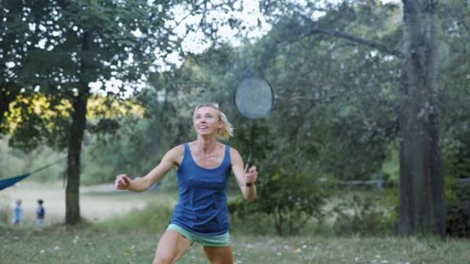漂亮微笑的运动健身女子在公园打羽毛球