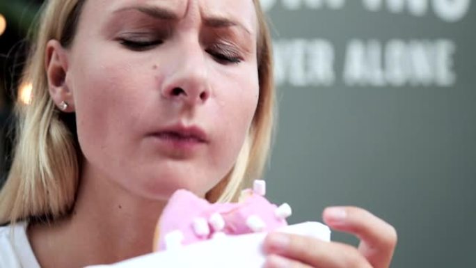 吃甜甜圈的幸福女人。带甜点的女性