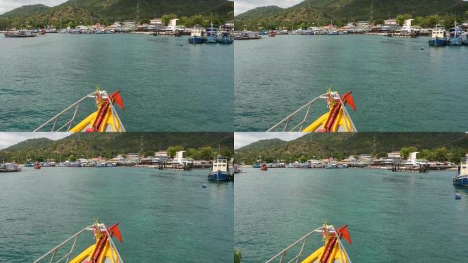带有护身符的渔船进入港口。带有泰国宗教护身符的明亮船漂浮在泰国高陶天堂岛上的潜水胜地港口。