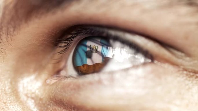 人的棕色眼睛在近距离与危地马拉旗在虹膜，与风的运动。视频的概念