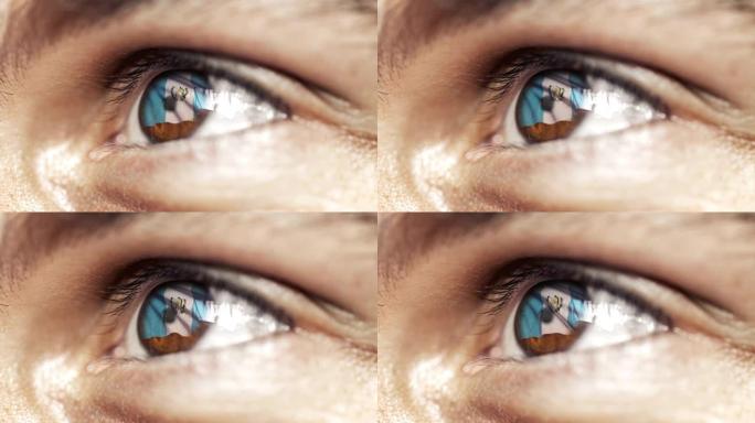 人的棕色眼睛在近距离与危地马拉旗在虹膜，与风的运动。视频的概念