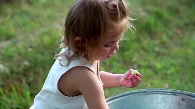 一个小女孩在盆子里洗手的侧视图