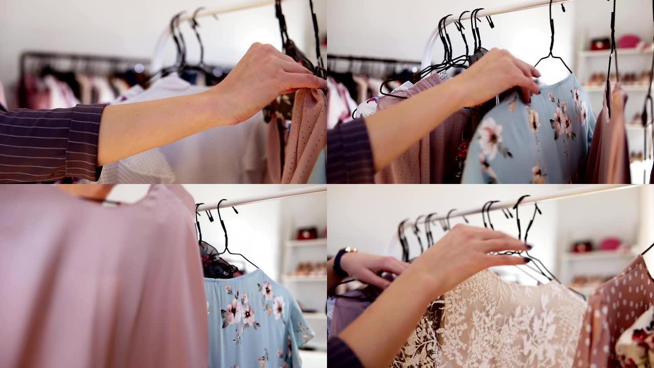 女人的手在商店的衣架上选择衣服。名牌服装，时尚服装，丝绸衬衫