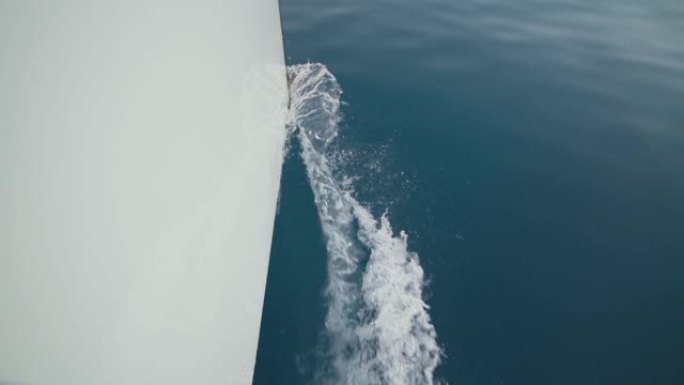 美丽的白色游艇破浪前进，慢动作拍摄。清澈的蓝色水。波浪飞溅向不同方向爆炸