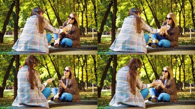 和蔼可亲的女孩坐在秋季公园使用智能手机应用程序