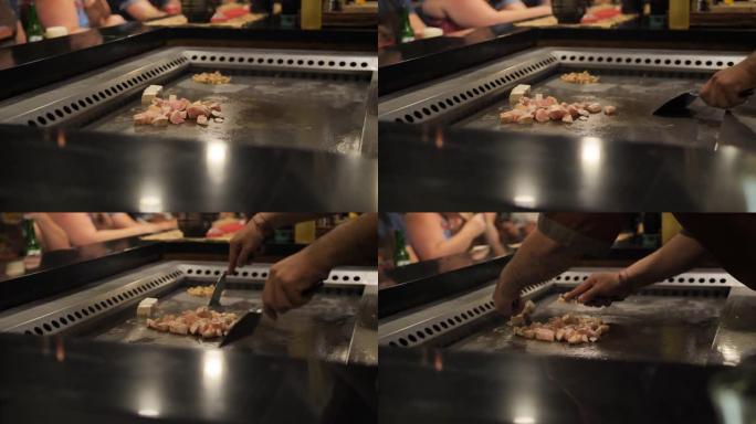 亚洲厨师在大炉子上为观众切鸡肉