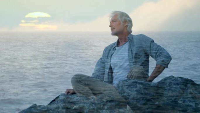 老人坐在岩石上，可以看到大海
