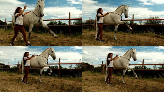 一名年轻女子和一匹马在围场上，马抬起双腿。