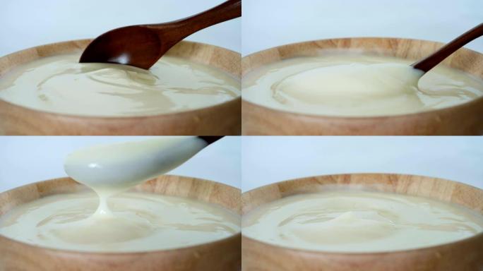 关闭发酵乳益生菌酸奶，健康食品，用勺子混合奶油凝乳