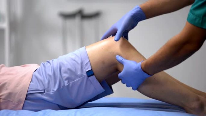 创伤医生检查女性患者的膝盖，半月板炎