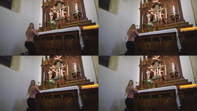 女人跪在天主教教堂祈祷