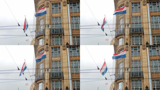 阿姆斯特丹老房子的旗杆上悬挂着荷兰的旗帜