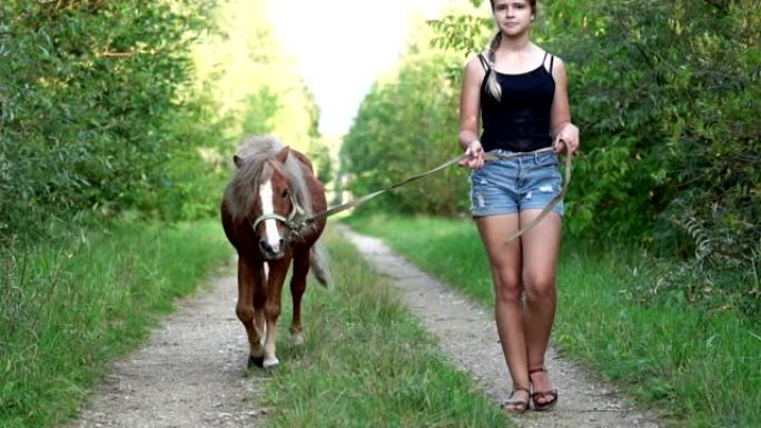 十几岁的女孩在夏天沿着美丽的乡间小路散步