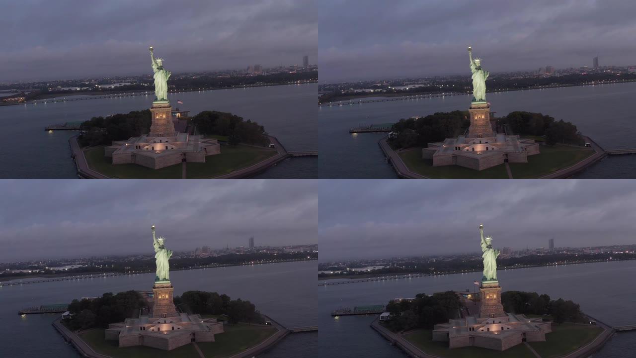 空中: 盘旋的自由女神像在清晨的灯光下美丽地照亮了4k纽约市