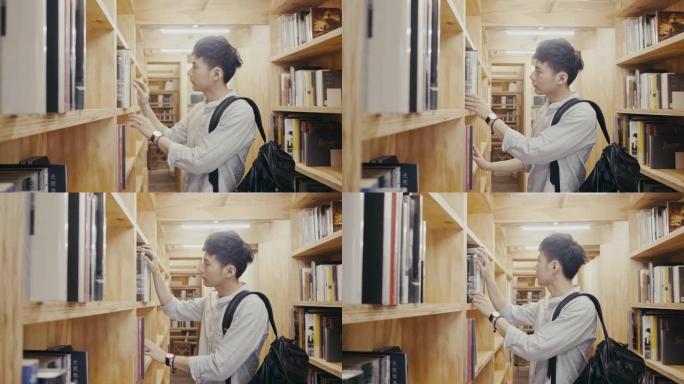 年轻的亚洲男大学生在图书馆寻找书籍 (慢动作)