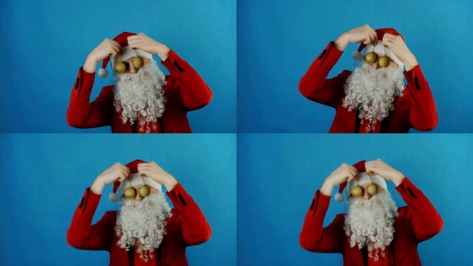 新2019年，像圣诞老人一样的男人，蓝色背景上的金色圣诞球小玩意玩具