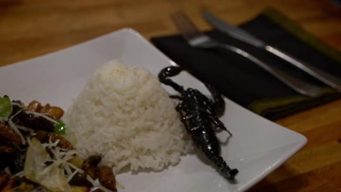 慢动作女人在亚洲餐厅吃一盘蜘蛛和虫子