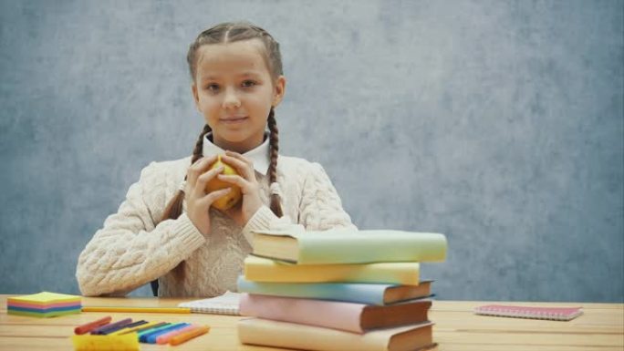 小学生拿着多汁的大苹果。很快她就会尝到。