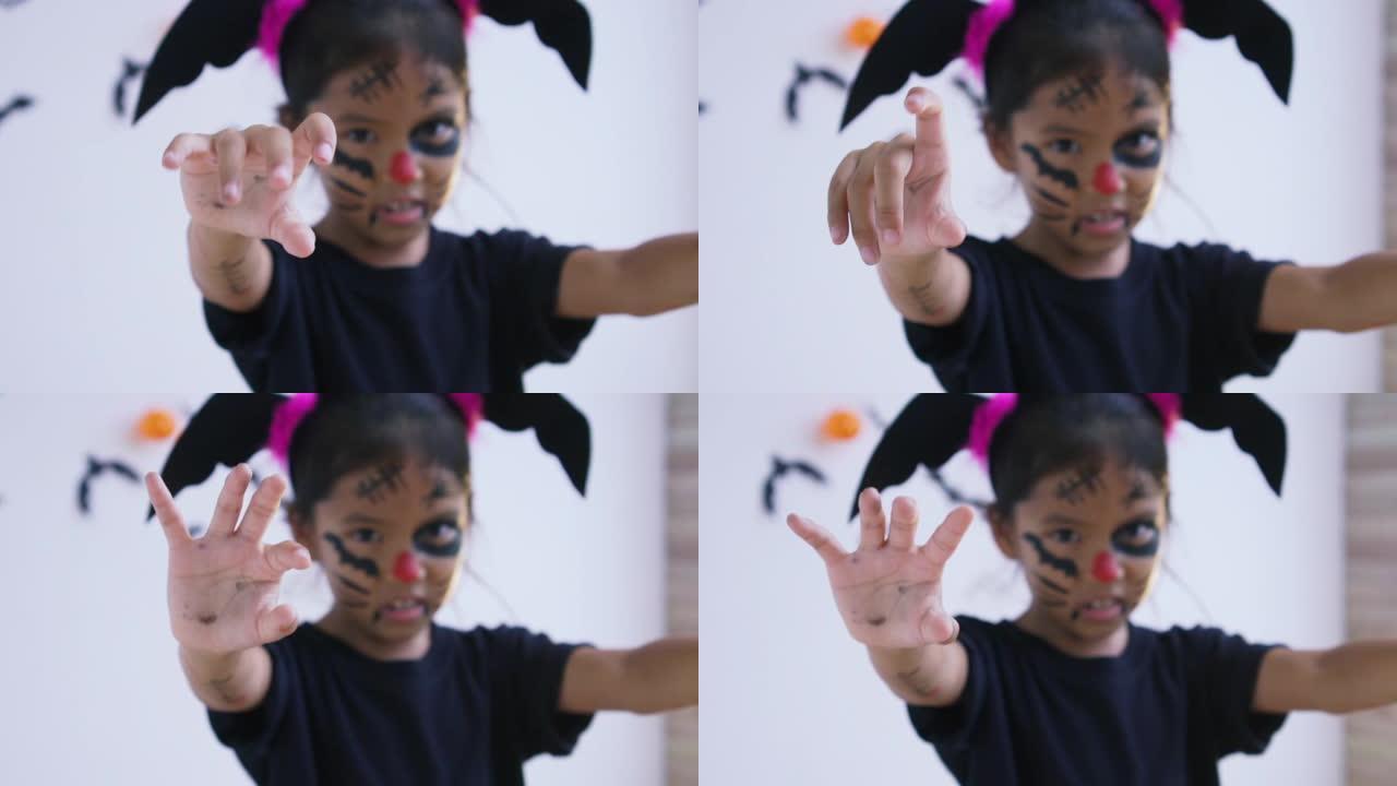 亚洲女孩的手摇着手指在万圣节创造一个把戏