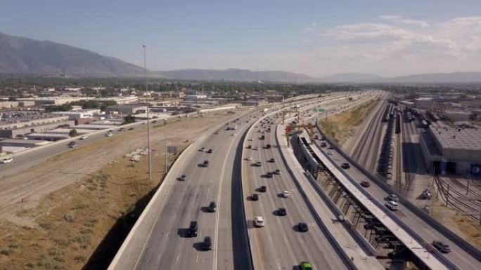空中无人机剪辑俯视I-15，盐湖城通勤交通和火车的I-80