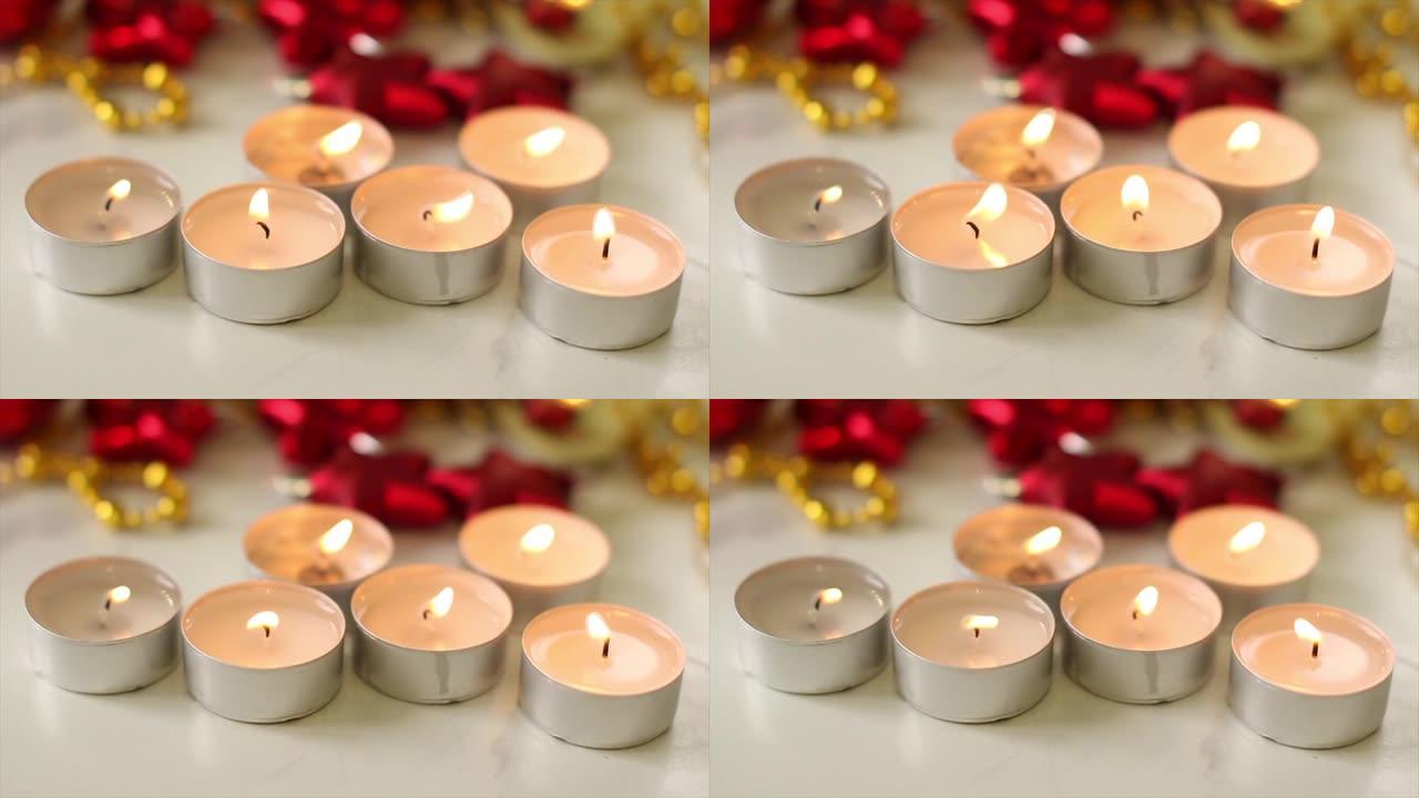 白色桌子上有红色和金色圣诞装饰品的白色蜡烛