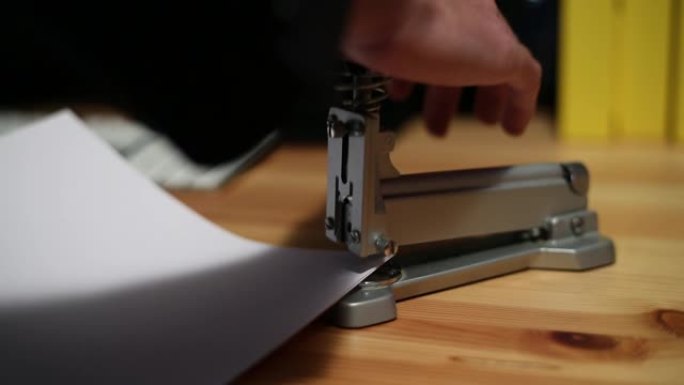 秘书手在办公桌上使用纸上的翻纸机