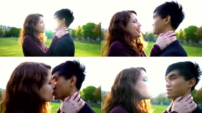 年轻的亚洲高加索夫妇在日落时在公园接吻，阳光照在后面