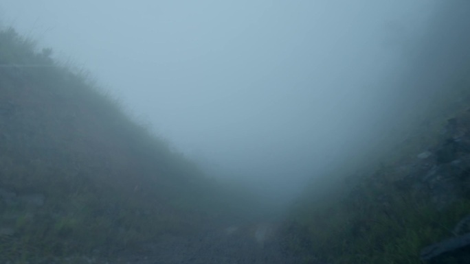 大雾可见度低汽车行驶在山路上