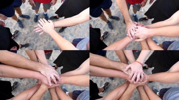 年轻运动员的男性双手团结一致。一群最好的朋友将他们的手臂放在一个圆圈的中心，然后放下。友谊和团队合作
