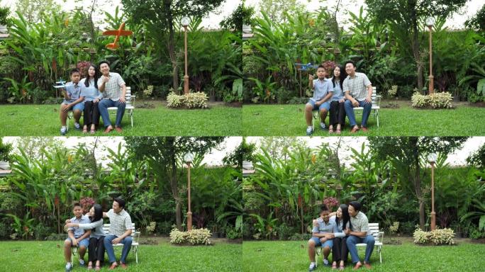 快乐的亚洲家庭母亲，父亲和儿子。他们在家里的花园里一起玩飞机模拟。家庭度假。慢动作
