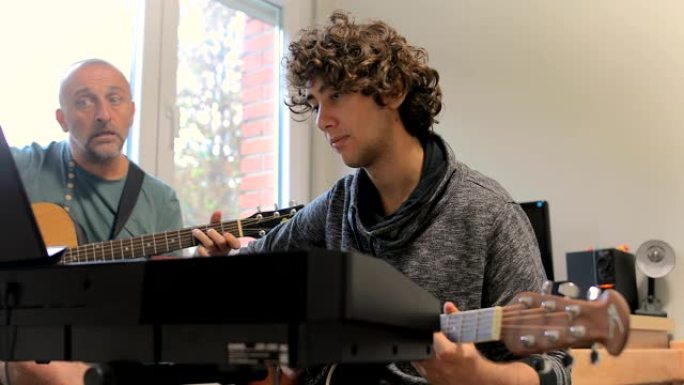男生和老师在客厅弹吉他
