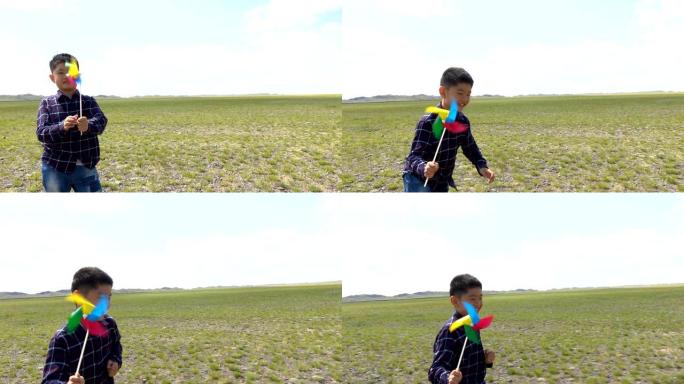 在草原上与风车一起奔跑的亚洲男孩