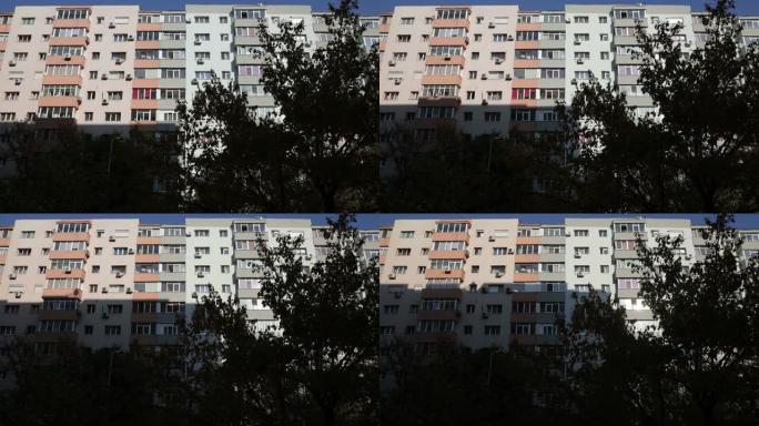 在罗马尼亚布加勒斯特，太阳落山的短暂时间流逝，并在附近的公寓楼上投下了一座建筑物的大阴影。