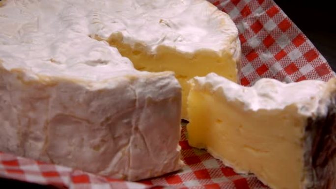 柔软的卡马伯特奶酪的部分紧挨着整个