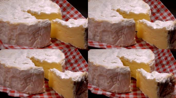 柔软的卡马伯特奶酪的部分紧挨着整个