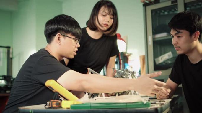 亚洲首席工程师咨询引擎俱乐部与实验室的学生工程实习生一起描述了发动机零件的操作。小工具、发展和生产力