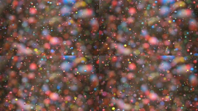 明亮的节日背景。混沌运动粒子。彩色气泡油美丽油漆多色宇宙移动。太空星系行星。表面慢动作。节日快乐圣诞