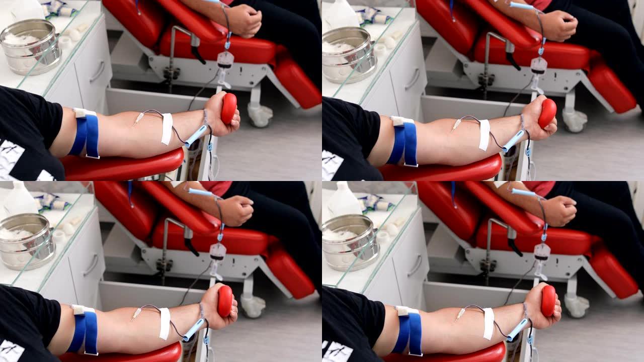 善行。为身体献血的好处。接受输血的朋友的手。献血者在医疗诊所献血的特写