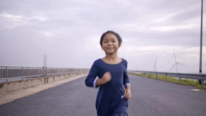 亚洲母女在清晨在风力涡轮机跑步公园慢跑、散步、玩耍。
