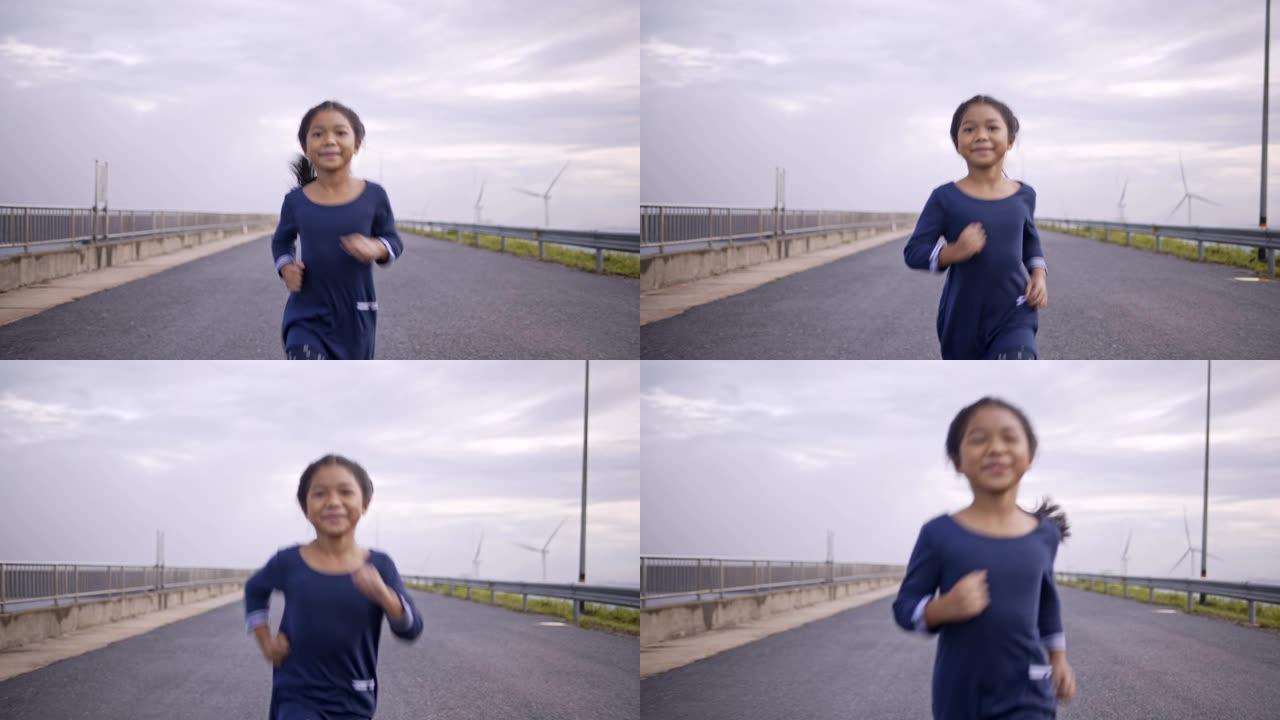 亚洲母女在清晨在风力涡轮机跑步公园慢跑、散步、玩耍。