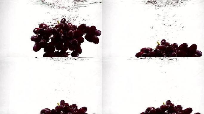慢动作的红葡萄。一束葡萄浸泡在带有气泡的水中。