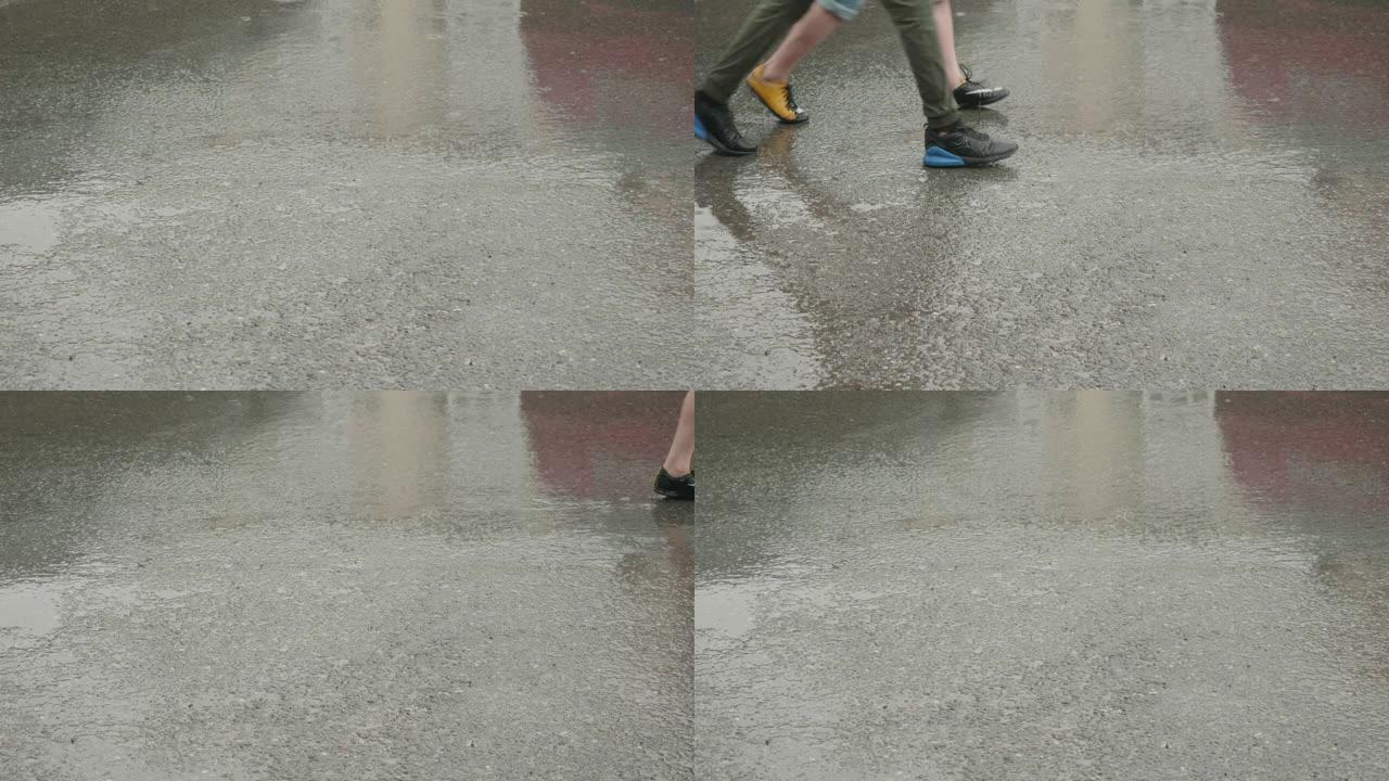 女孩和男孩的腿在雨路上湿着的灰色路上行走，侧视图。