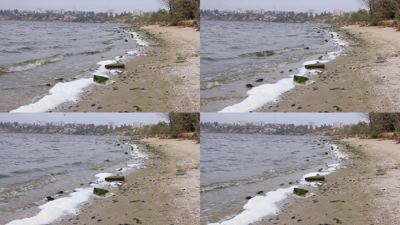 波浪在河岸上滚动，用泡沫敲打石头