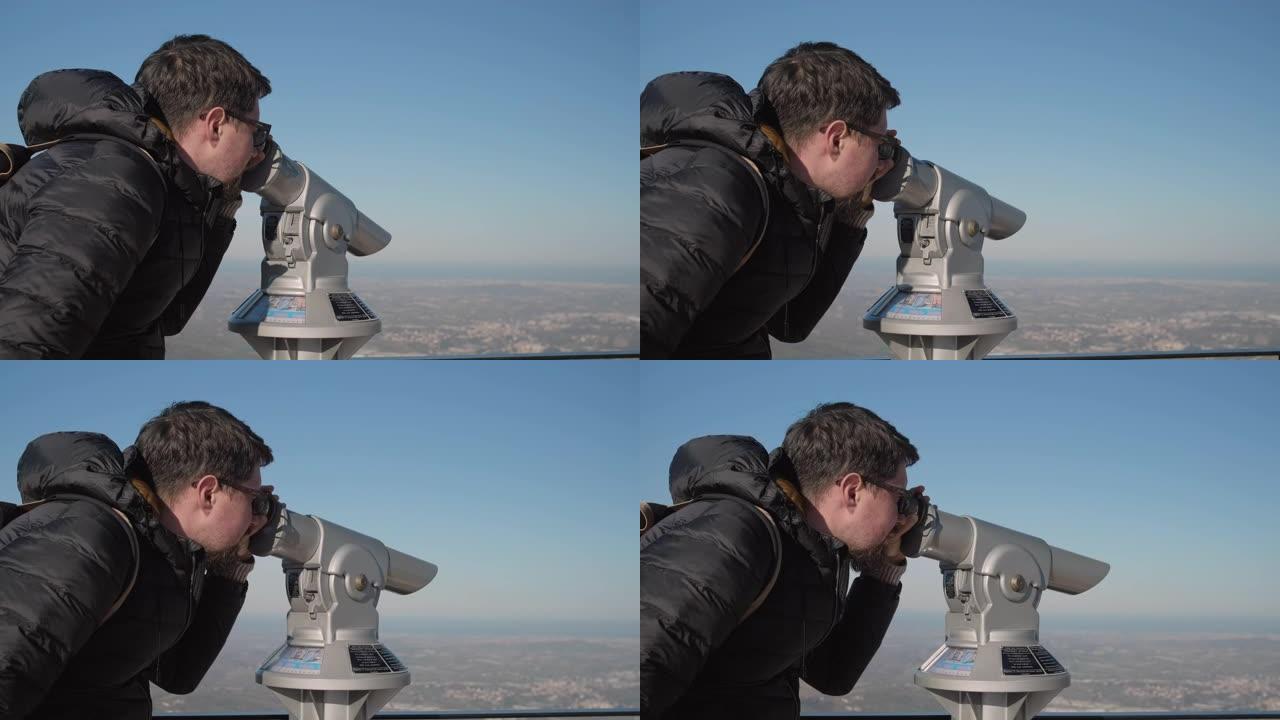 男子通过旅游双筒望远镜看着城市景观