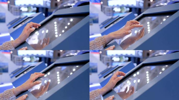 在技术展览会上使用交互式触摸屏显示器的女人