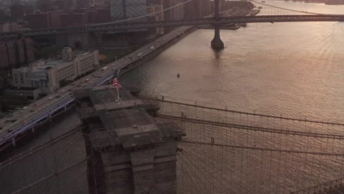 空中: 在布鲁克林大桥上近距离飞行，带有美国国旗和东河景，在美丽的4K曼哈顿纽约市天际线
