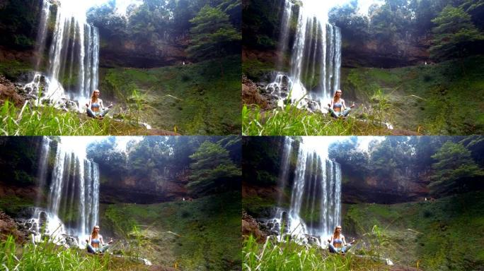 风浪草女孩在瀑布上摆出调息瑜伽姿势