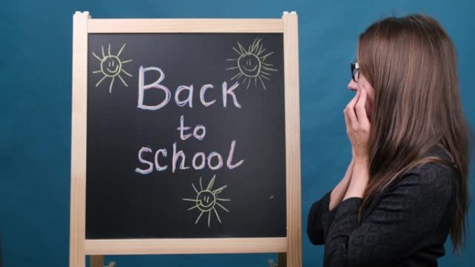 回到学校，一位戴眼镜的女老师站在黑板附近，并显示了题词